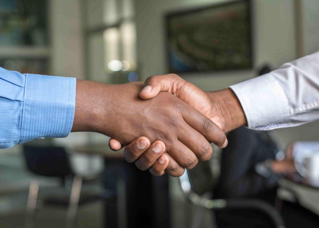 Business professionals shaking hands after successfully migrating a Kohana project to PHP 8